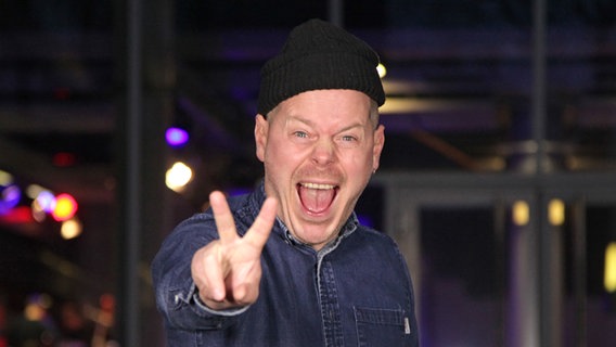 König Boris von Fettes Brot zeigt das "Victory"-Zeichen und hat den Mund weit aufgerissen. © NDR 