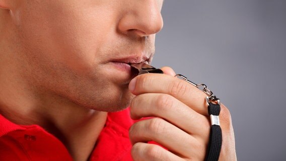 Ein Mann mit Trillerpfeife im Mund. © fotolia Foto: BlueSkyImages