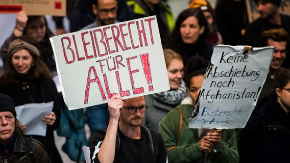 Abschiebe-Gegner demonstrieren mit Plakaten auf dem Frankfurter Flughafen.  Foto: Susann Prautsch