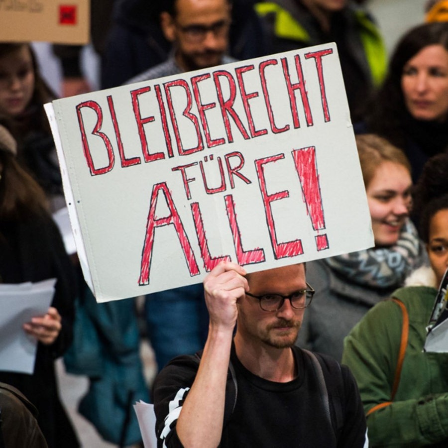 Abschiebe-Gegner demonstrieren mit Plakaten auf dem Frankfurter Flughafen.  Foto: Susann Prautsch