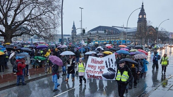 Demonstration von Impfgegnern in Hamburg. Sie halten ein Plakat mit "Hände weg von unseren Kindern" hoch. © Georg Wendt/dpa Foto: Gerog Wendt