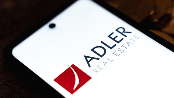 Adler Real Estate Logo auf einem Smartphone-Display.  
