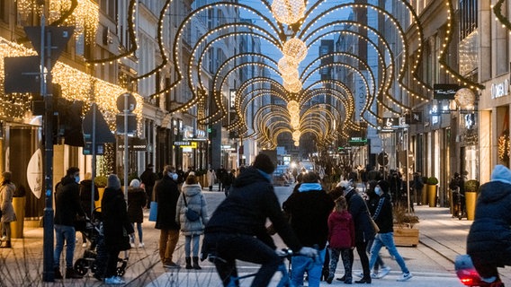 Menschen flanieren durch die weihnachtlich illuminierte Haburger Innenstadt. © dpa Foto: Markus Scholz