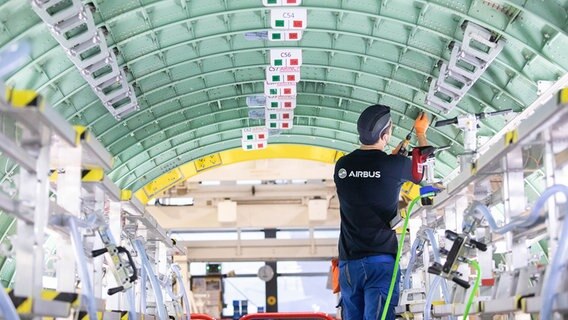 Ein Airbus-Techniker arbeitet in einem Rumpfsegment in der neuen Strukturmontage der Airbus A320 Familie in Hangar 245 im Airbus Werk in Finkenwerder. © picture alliance/dpa Foto: Christian Charisius