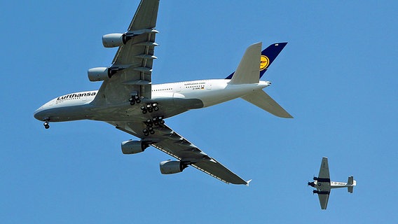 Das Flugzeug Ju 52 D-AQUI (hinten) und ein Airbus A380 fliegen über Hamburg. © dpa Foto: Malte Christians