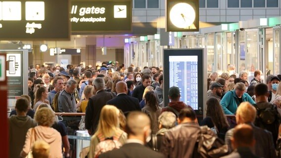 Zahlreiche Reisende warten in Schlangen vor der Sicherheitskontrolle am Hamburger Flughafen. © picture alliance / dpa 