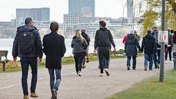 Menschen gehen an der Außenalster in Hamburg spazieren. © Markus Scholz Foto: picture alliance / dpa