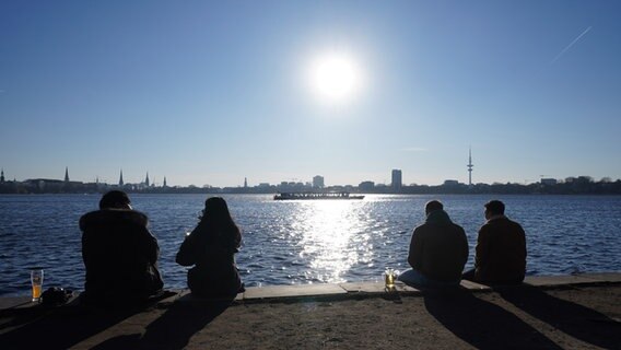 Menschen genießen die Nachmittagssonne an der Außenalster in Hamburg. © picture alliance/dpa Foto: Marcus Brandt
