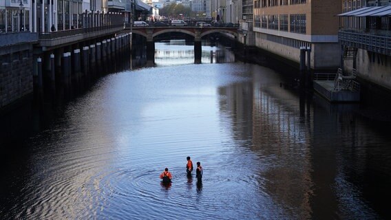 Mitarbeiter des Landesbetriebs Straßen, Brücken und Gewässer stehen in einem fast wasserleeren Alsterfleet. © picture alliance/dpa | Marcus Brandt Foto: Marcus Brandt