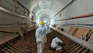 Mit Schutzmasken überprüfen Arbeiter Tübbings in der Weströhre des Alten Elbtunnels. © NDR Foto: Petra Volquardsen