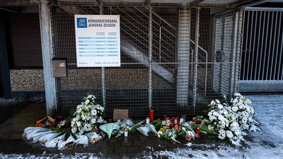 Blumen und Kerzen vor dem Eingang eines Gebäudes der Zeugen Jehovas in Hamburg, in es am 9. März ein Amoklauf gab. © Daniel Bockwoldt/dpa 