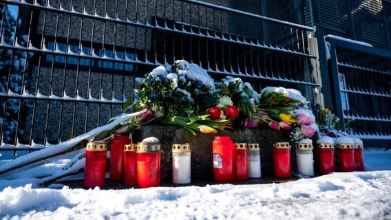 Flowers and candles in front of the entrance to a Jehovah's Witnesses building in Hamburg where there was a killing spree on March 9.  © Daniel Bockwoldt/dpa 