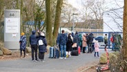 Zahlreiche Geflüchtete stehen in einer Schlange zur Registrierung am Ankunftszentrum Rahlstedt im Bargkoppelweg. © picture alliance/dpa Foto: Jonas Walzberg