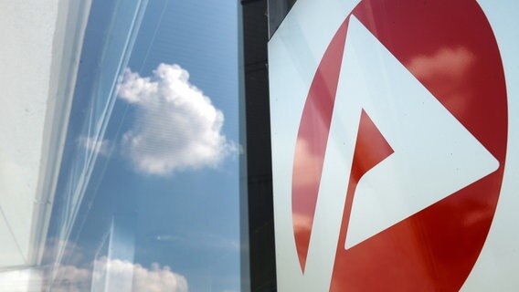 Das Logo vom Jobcenter spiegelt sich am Eingang. © picture alliance/dpa Foto: Jens Kalaene