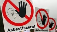 Mehrere Schilder mit der Aufschrift "Asbestfasern" warnen vor Asbest. © Daniel Bockwoldt/dpa Foto: dpa