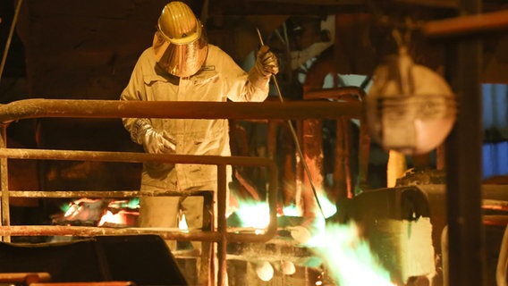 Ein Arbeiter mit Schutzkleidung bei der Kupferproduktion. © picture alliance/dpa Foto: Bodo Marks