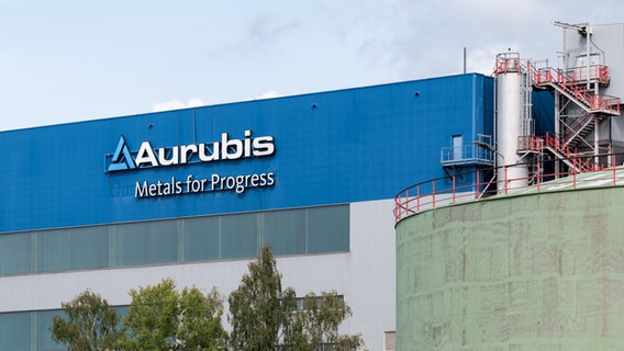 Der Schriftzug "Aurubis, Metalls for Progress" steht an einer Produktionshalle des Hamburger Werks. © picture alliance/dpa Foto: Markus Scholz