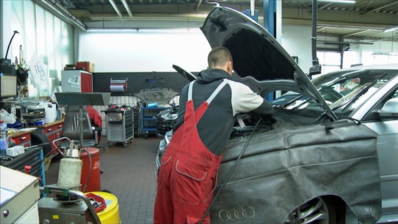 Ein Auszubildender bei der Arbeit an einem Auto in der Kfz-Werkstatt. © NDR Foto: Screenshot