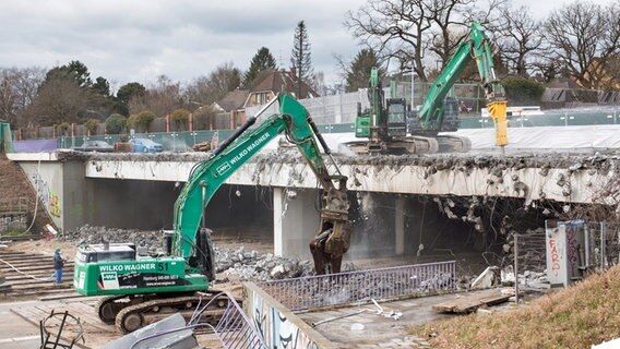Zwei Bagger sind mit Abbrucharbeiten an einer Brücke über die Autobahn A7 an der Abfahrt Hamburg-Othmarschen beschäftigt. © picture alliance / dpa 