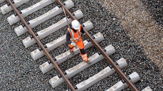 Ein Arbeiter geht in Hamburg über eine noch nicht fertige Gleisanlage. © picture alliance / dpa Foto: Lukas Schulze