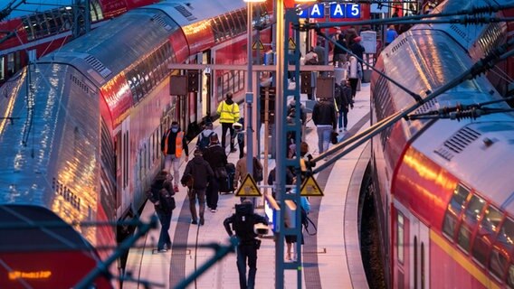 Reisende gehen im Hamburger Hauptbahnhof über einen Bahnsteig. © picture alliance / dpa Foto: Daniel Bockwoldt