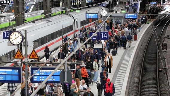 Reisende warten im Hauptbahnhof in Hamburg auf ihren Zug. © Bodo Marks/dpa 