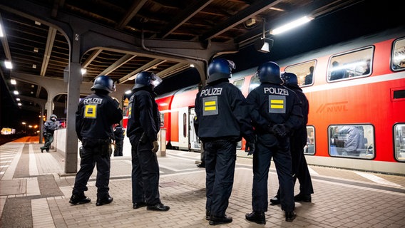 Einsatzkräfte der Bundespolizei stehen am Bahnhof Bergedorf an einem Regionalzug. © picture alliance/dpa 