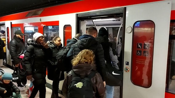 Mehrere Menschen steigen in Hamburg in eine S-Bahn ein. © NDR Foto: Screenshot