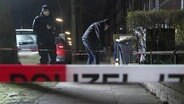 Einsatzkräfte der Polizei stehen vor einem abgeseperrten Tatort in Barmbek-Nord. © TV News Kontor Foto: Screenshot