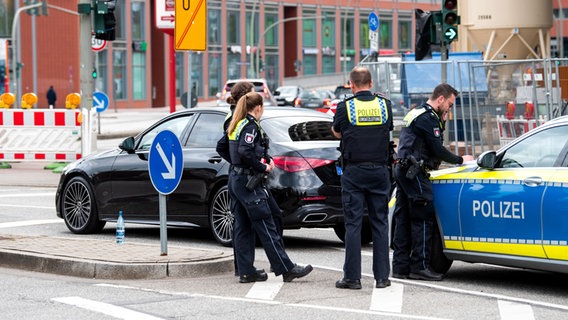 Einsatzkräfte der Hamburger Polizei stehen im Stadtteil Bergedorf an einem Auto, in dem zwei Personen mit Messerstichen saßen. © picture alliance / dpa Foto: Daniel Bockwoldt