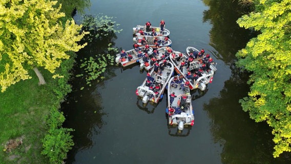 Mehrere Boote der Jugendfeuerwehr stehen zusammen auf einem Fluss. © NDR 