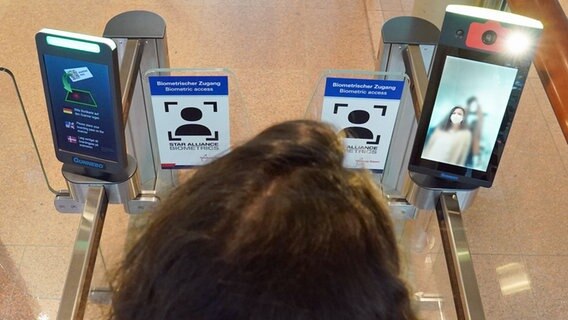 Eine Frau geht durch die biometrische Gesichtserkennung vor der Sicherheitskontrolle im Abflugbereich des Hamburg Airports. © picture alliance / dpa Foto: Marcus Brandt