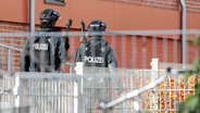 Zwei bewaffnete Polizisten vor der Stadtteilschule Blankenese. Dort wurde zuvor eine Lehrerin bedroht. © picture alliance / dpa Foto: Bodo Marks