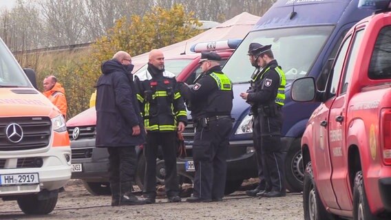 Einsatzkräfte der Polizei stehen zusammen. © TV-Elbnews Foto: Screenshot