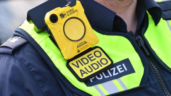Ein Polizist trägt in Schulterhöhe eine Bodycam an der Uniform. (Archivfoto) © picture alliance / SVEN SIMON Foto: Frank Hoermann / SVEN SIMON
