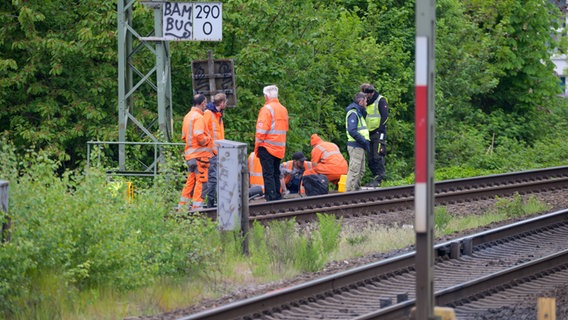 Arbeiter der Deutschen Bahn (DB) arbeiten nahe dem S-Bahnhof Sternschanze am Brandort an den Gleisen. Wegen eines Kabelbrandes in Hamburg kommt es im Fernverkehr zu starken Beeinträchtigungen. © dpa Foto: Jonas Walzberg