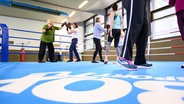 Die Teilnehmerinnen eines Kurses trainieren im Ring der Boxsporthalle Hamburg. © dpa Foto:  Jonas Walzberg