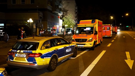 Polizeiwagen und Rettungswagen stehen auf einer Straße in Hamburg-Jenfeld. © picture alliance 