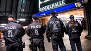 Einsatzkräfte der Bundespolizei stehen für ein Foto vor dem Hauptbahnhof mit der Wandelhalle zusammen. Die Bundespolizei hat für dieses Wochenende am Hamburger Hauptbahnhof ein temporäres Waffenverbot verhängt. © picture alliance/dpa Foto: Daniel Bockwoldt