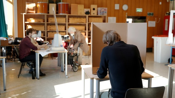 Mehrere Menschen in einem Wahllokal im Hamburger Stadtteil Harvestehude. © NDR Foto: Zeljko Todorovic