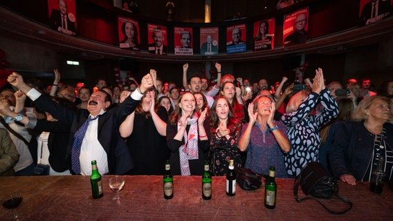 Melanie Leonhard (SPD, 4.v.r, erste Reihe), Gesundheitssenatorin Hamburgs, reagiert mit Teilnehmern der Hamburger Wahlparty der SPD im Mojo Club auf der Reeperbahn auf erste Hochrechnungen. © Picture Alliance/dpa Foto:  Jonas Walzberg