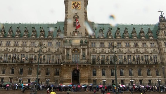 Menschen haben sich vor dem Charles-Besuch am Vormittag auf dem Rathausmarkt eingefunden. © NDR Screenshot 