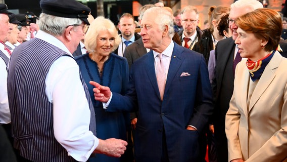 Königsgemahlin Camilla, König Charles III. von Großbritannien, Bundespräsident Frank-Walter Steinmeier und seine Frau Elke Büdenbender im Gespräch mit dem Hamburger Shanty-Chor de Tampentrekker. © dpa-Bildfunk Foto: Jonas Walzberg/