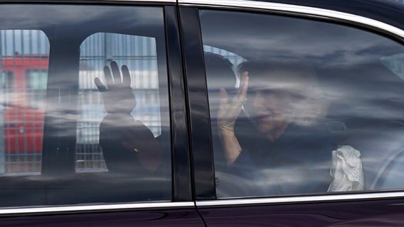 König Charles III. und Königsgemahlin Camilla winken bei ihrem Hamburg-Besuch aus einer Limousine. © dpa-Bildfunk Foto: Marcus Brandt/ dpa