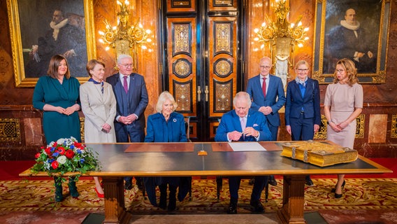 Königin-Gemahlin Camilla und König Charles III. tragen sich im Hamburger Rathaus in das Goldene Buch der Stadt ein. © picture alliance/dpa/Senatskanzlei Hamburg | Senatskanzlei Hamburg Foto: Senatskanzlei Hamburg/dpa