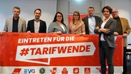 Tanja Chawla, Vorsitzende des DGB Hamburg (r.) präsentiert mit anderen Gewerkschaftsvertretern ein Transparent auf dem steht:" Eintreten für die Tarifwende" © picture alliance / dpa Foto: Rabea Gruber