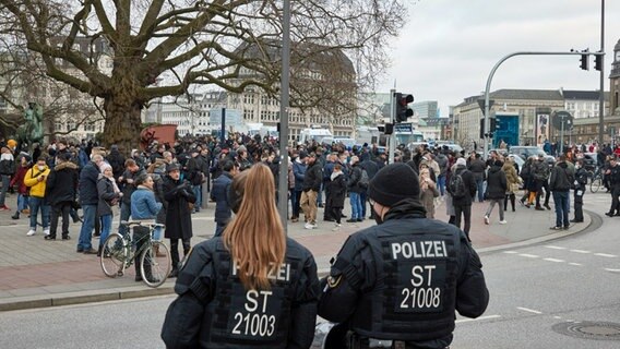 Polizistinnen beobachten Gegner der Corona-Maßnahmen, die sich trotz Verbots in Hamburg versammelt haben © dpa Foto: Georg Wendt/