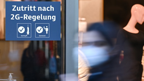 Ein Schild mit der Aufschrift "Zutritt nach 2G-Regelung" hängt an dem Eingangsbereich eines Kaufhauses. © dpa Foto: picture alliance/dpa | Arne Dedert