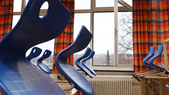 Ein leeres Klassenzimmer mit hochgestellten Stühlen und offenem Fenster. © picture alliance Foto: Frank May