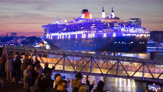 Zahlreiche Menschen verfolgen zum Auftakt der Cruise Days, wie das Kreuzfahrtschiff Queen Mary 2 durch den Hamburger Hafen fährt. © picture alliance/dpa | Bodo Marks Foto: Bodo Marks